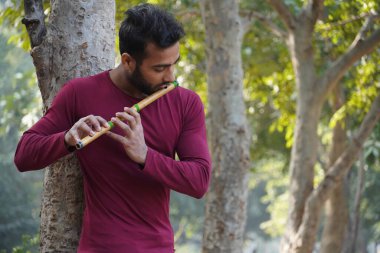 Bir adam müzik aleti flüt çalıyor.