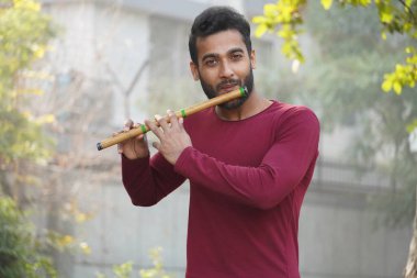 Bir adam müzik aleti flüt çalıyor.