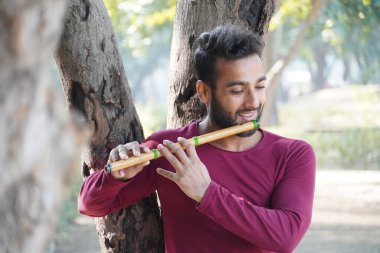 Bir adam flüt çalıyor.