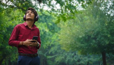 Cep telefonu ve kulaklığı olan adam.