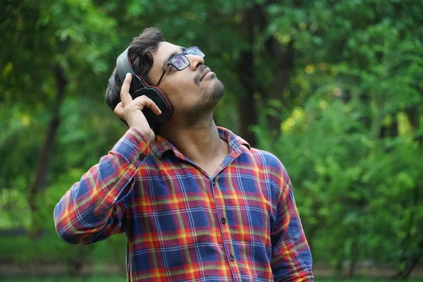 Kulaklık kullanarak podcast dinleyen adam