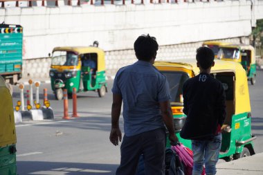 İnsanlar durakta otobüs bekliyor.