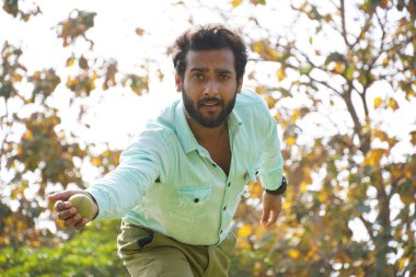 Kriket topu kullanan bir adam.