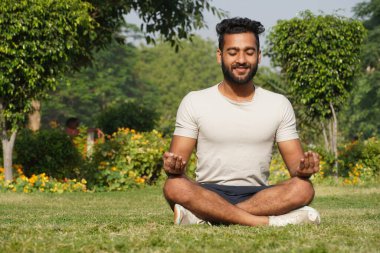 Parkta meditasyon yapan bir adam - Sağlık ve Fitness konsepti