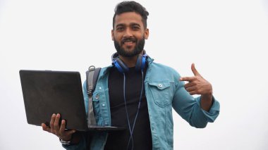 Laptop ve kulaklıklı genç adam.