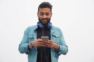 Genç çocuk cep telefonu kullanıyor ve mutlu bir şekilde izliyor.