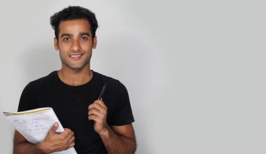 Kitapları ve kalemle izole edilmiş geçmişi olan genç bir öğrenci - Eğitim Konsepti