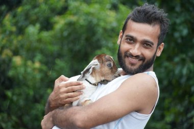 İskelede keçi besleyen bir çocuk.