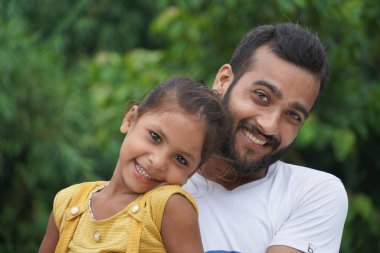 Sevimli bir kızı evlat edinen bir çocuk, her ikisi de gülümsüyor.