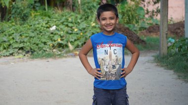 Küçük sevimli bir çocuk gülümsüyor.