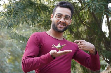 Gözlüklü bir adam ve elinde Alaaddin 'in lambası.