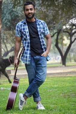 Gitarlı genç bir çocuk.