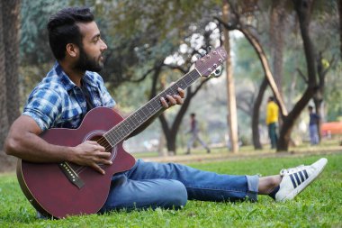 Gitarlı genç bir çocuk.