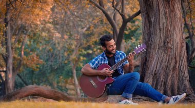 Gitar çalan bir çocuk.