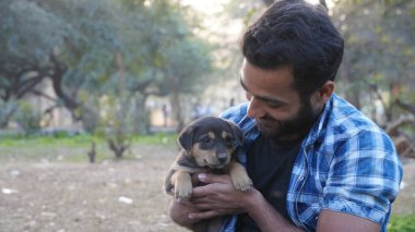 Parkta sevimli bir köpeği olan genç bir çocuk.