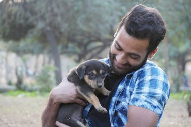 Parkta sevimli bir köpeği olan genç bir çocuk.