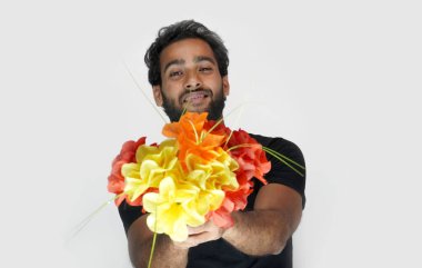 Erkek kadına çiçek kullanarak evlenme teklif ediyor.