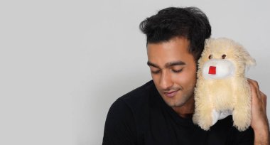 Oyuncak ayısıyla rahatlamış hisseden bir adam