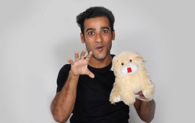 Mutlu yüz ifadesi takınan ve köpek oyuncağı olan bir adam.