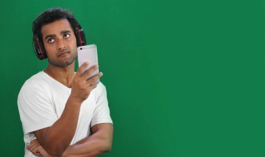 Genç adam cep telefonu kullanıyor ama mutlu değil.