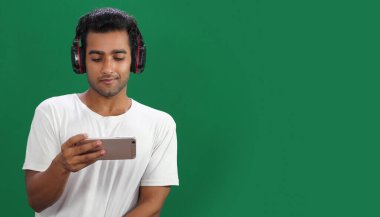 Cep telefonu kullanan genç erkek. Kulaklık takıyor.