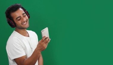 Mobil uygulama konseptinde müziğin tadını çıkaran bir adam.