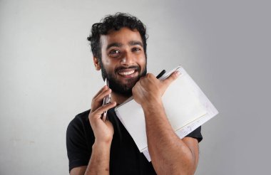 Beyaz arka planda kitapları ve kalemi olan bir adam.