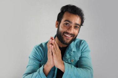 Hint usulü namaskar yapan beyaz arka planlı bir adam.