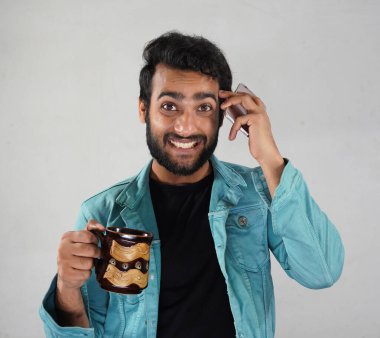 Elinde kahve fincanı olan bir adam.