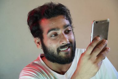 Cep telefonu kullanan ve mutlu bir adam.