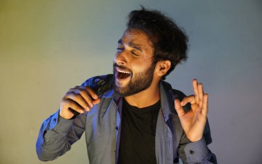 Adam mikrofonunu kullanarak yüksek nota söylemeye çalışıyor.