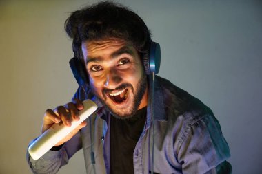 Adam uzaktan kumandayla yüksek sesle şarkı söylemeyi engellemeye çalışıyor.