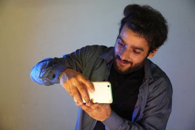 Adam cep telefonuyla fotoğraf çekiyor.