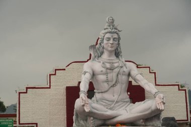 Hindu tanrısı Shiva heykeli, Hindistan 'ın Rishikesh kentindeki Ganj nehrinde meditasyonda oturuyor.,