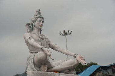 Hindu tanrısı Shiva heykeli, Hindistan 'ın Rishikesh kentindeki Ganj nehrinde meditasyonda oturuyor.,