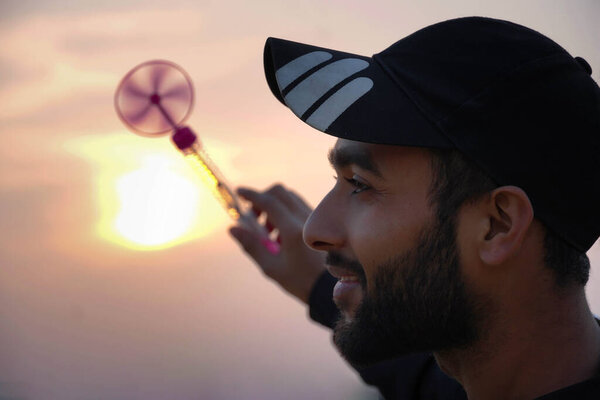 A man is spinning toy and sun is in background