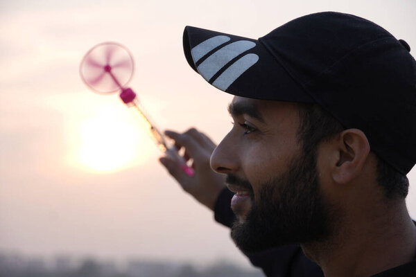 A man is spinning toy and sun is in background