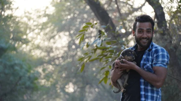 Parkta sevimli bir köpeği olan genç bir çocuk.