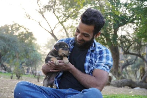 Parkta sevimli bir köpeği olan genç bir çocuk.