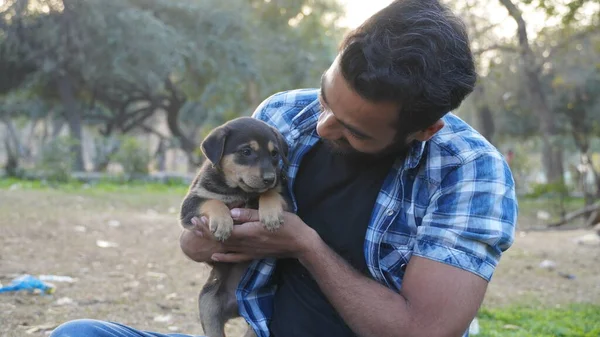 Parkta sevimli bir köpeği olan genç bir çocuk.
