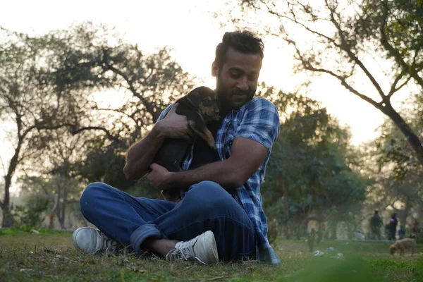 Parkta sevimli bir köpeği olan genç bir çocuk.