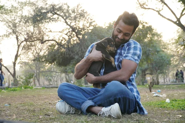 Parkta sevimli bir köpeği olan genç bir çocuk.