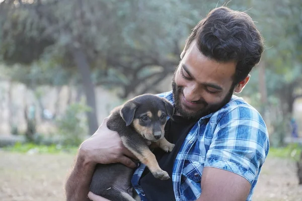 Parkta sevimli bir köpeği olan genç bir çocuk.
