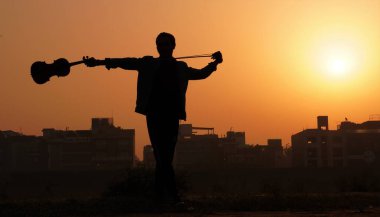 Keman çalan müzisyen. Müzik ve müzik tonu konsepti. İnsan müzisyeninin siluet görüntüleri