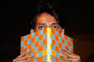 Adam günlük kapak ve yarım yüzünü gösteriyor.