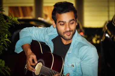 Güzel bir gecede gitar çalan bir gitarist.