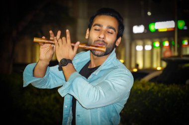 Genç bir adam tutkuyla flüt çalarken Anne de flüt çalıyor.