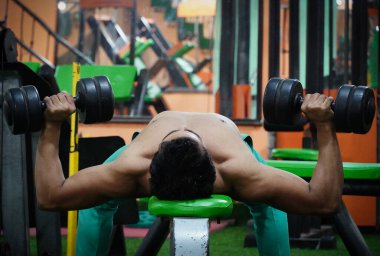 Spor salonunda ağırlık kaldırıyorum.