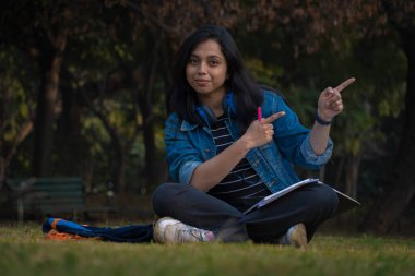 Güzel kızlar ellerini kullanarak bir şeyler gösteriyor.