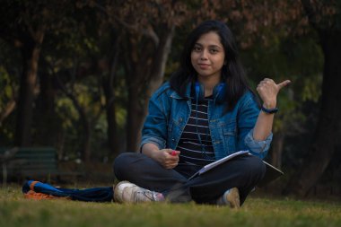 Güzel kızlar ellerini kullanarak bir şeyler gösteriyor.